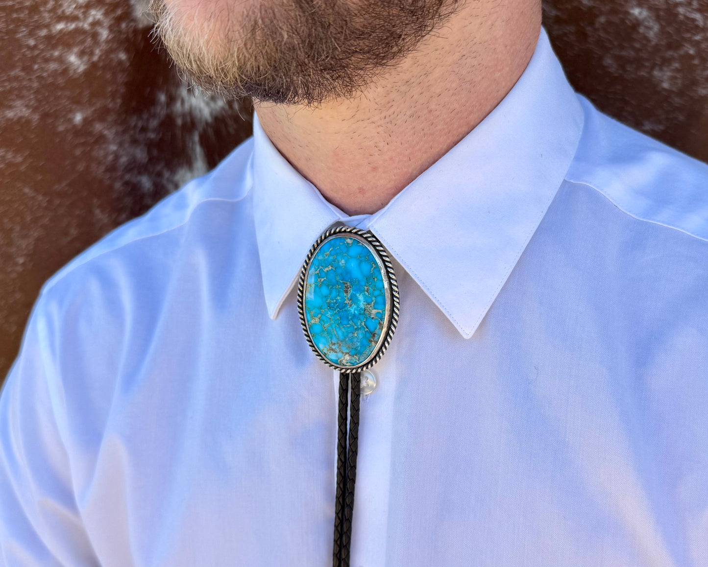 Bright Blue Kingman Turquoise Bolo Tie with dark brown leather cord and sterling silver tips