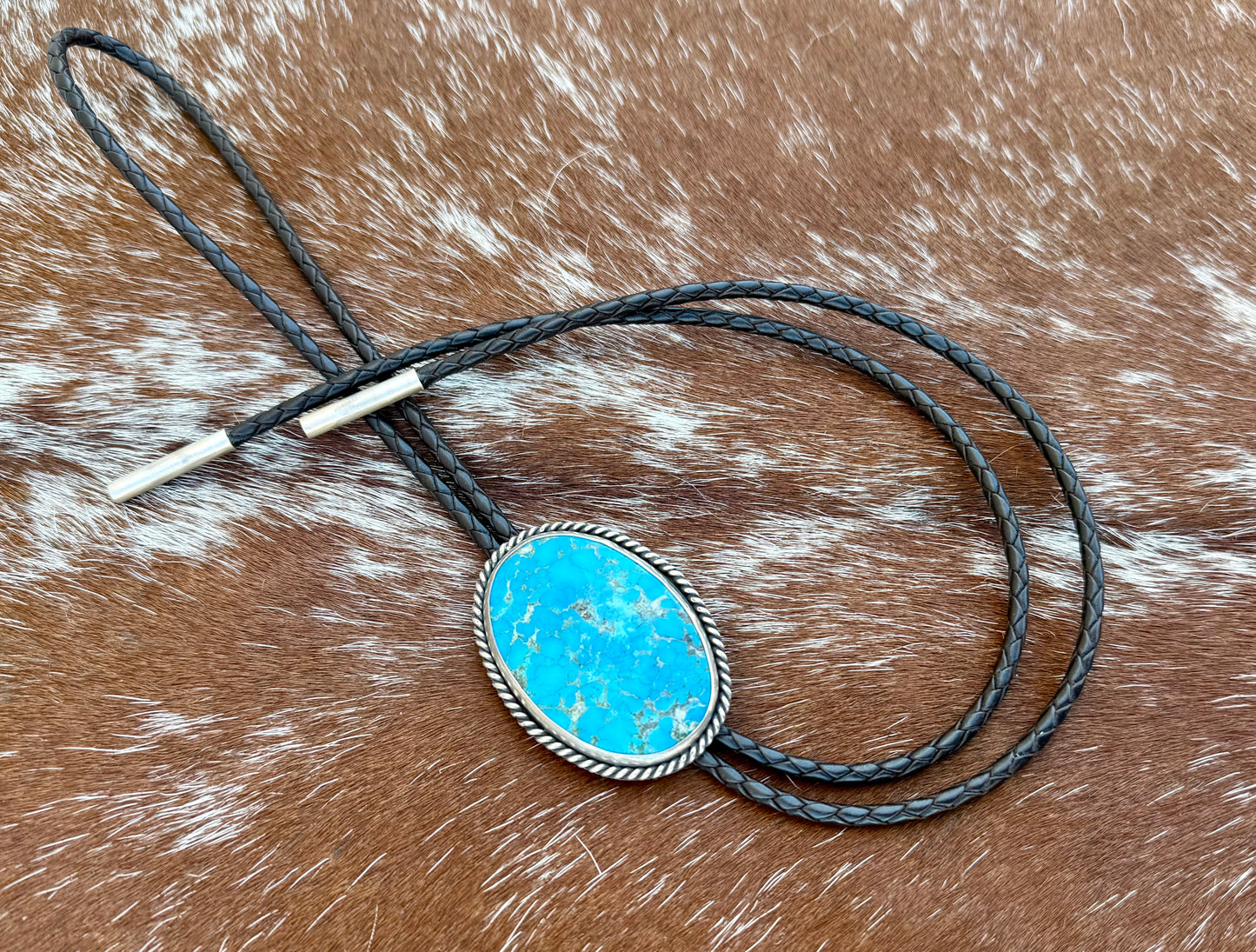 Bright Blue Kingman Turquoise Bolo Tie with dark brown leather cord and sterling silver tips