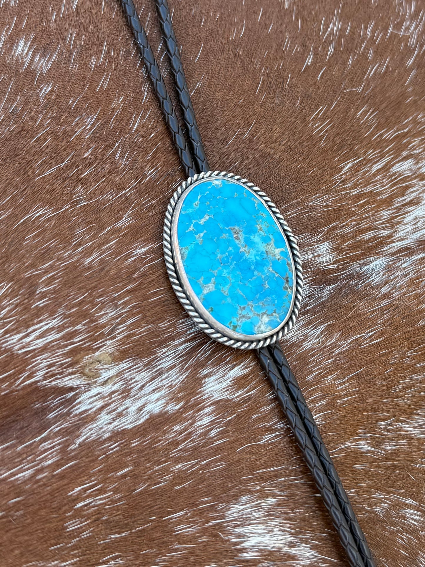 Bright Blue Kingman Turquoise Bolo Tie with dark brown leather cord and sterling silver tips