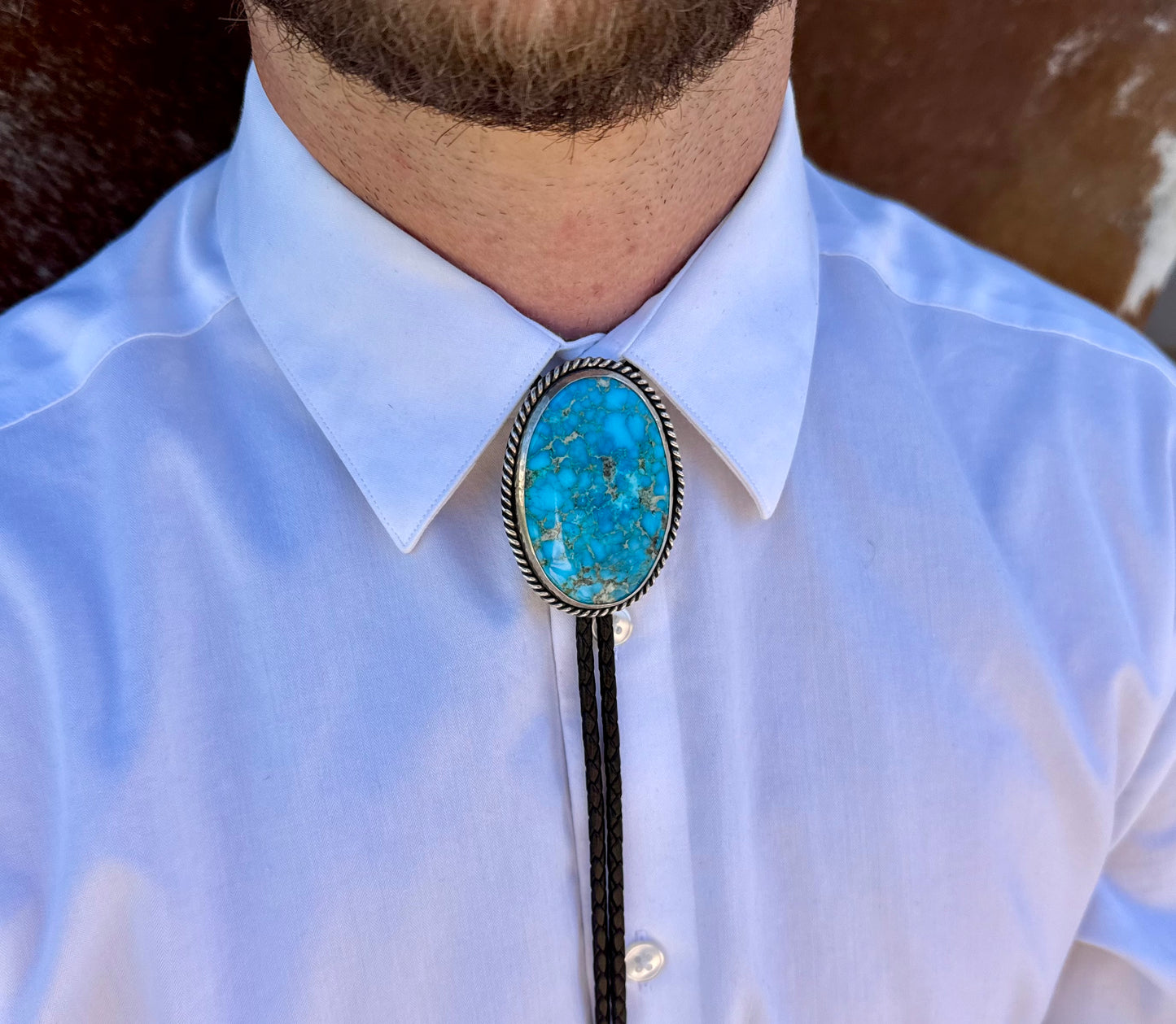 Bright Blue Kingman Turquoise Bolo Tie with dark brown leather cord and sterling silver tips
