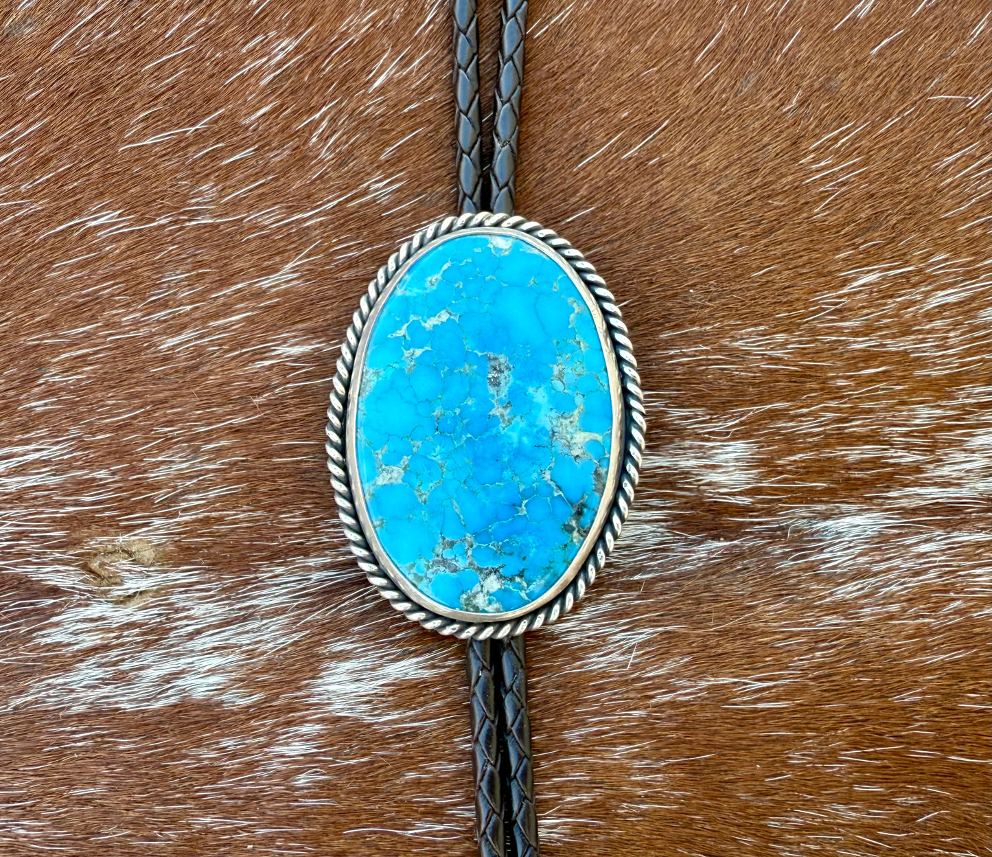 Bright Blue Kingman Turquoise Bolo Tie with dark brown leather cord and sterling silver tips